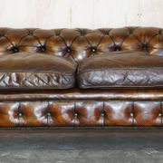 Victorian Chesterfield leather upholstered canapé with feather cushions.