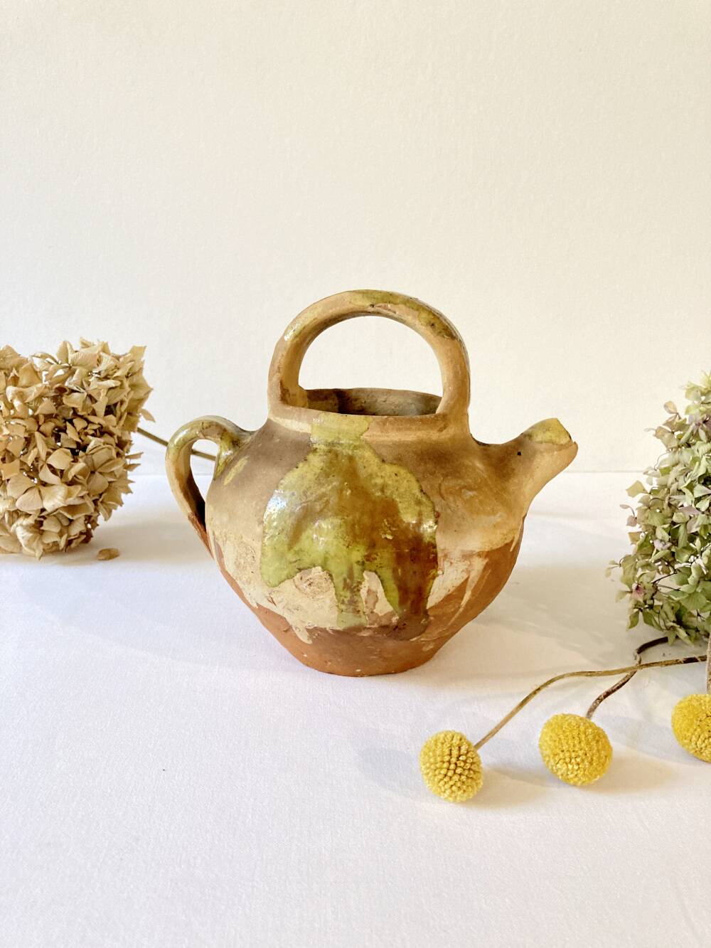 Small Provençal goat jug in creamy white and green enamelled stoneware
