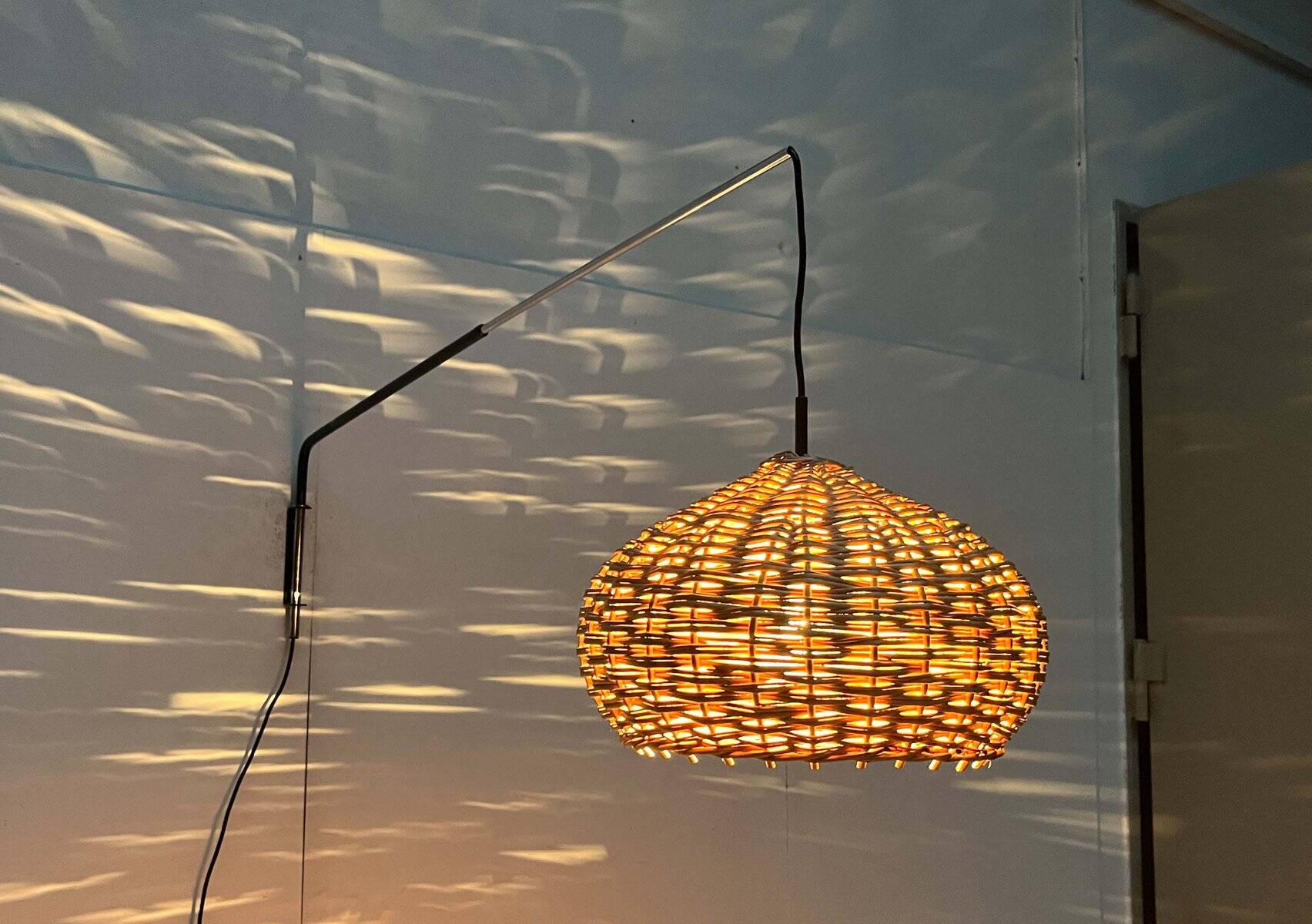 Mid-century modern Danish extendable cantilever wall lamp with a rattan shade, 1960s.