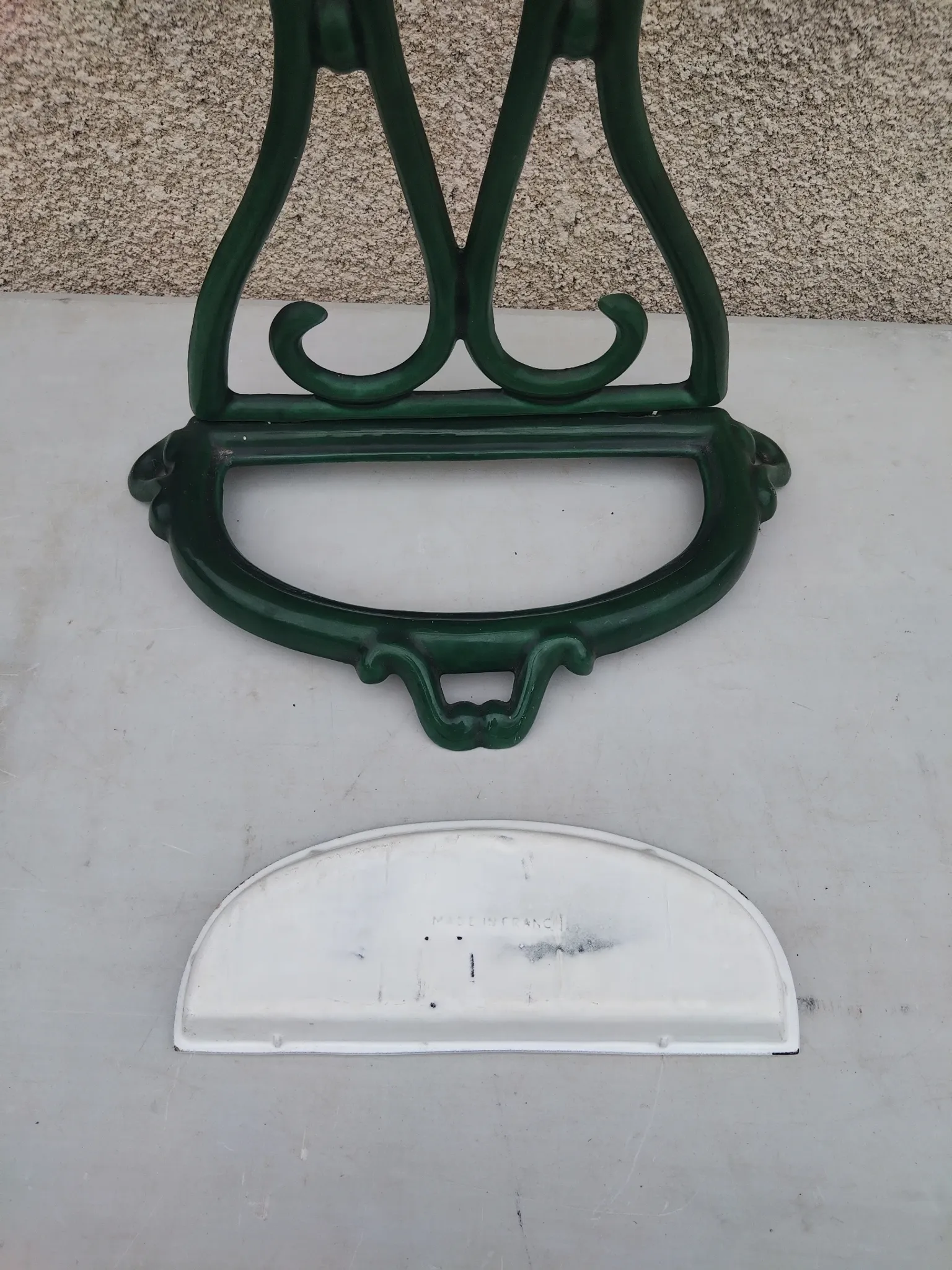 Bottle green enamelled cast iron umbrella stand with a swirl design.