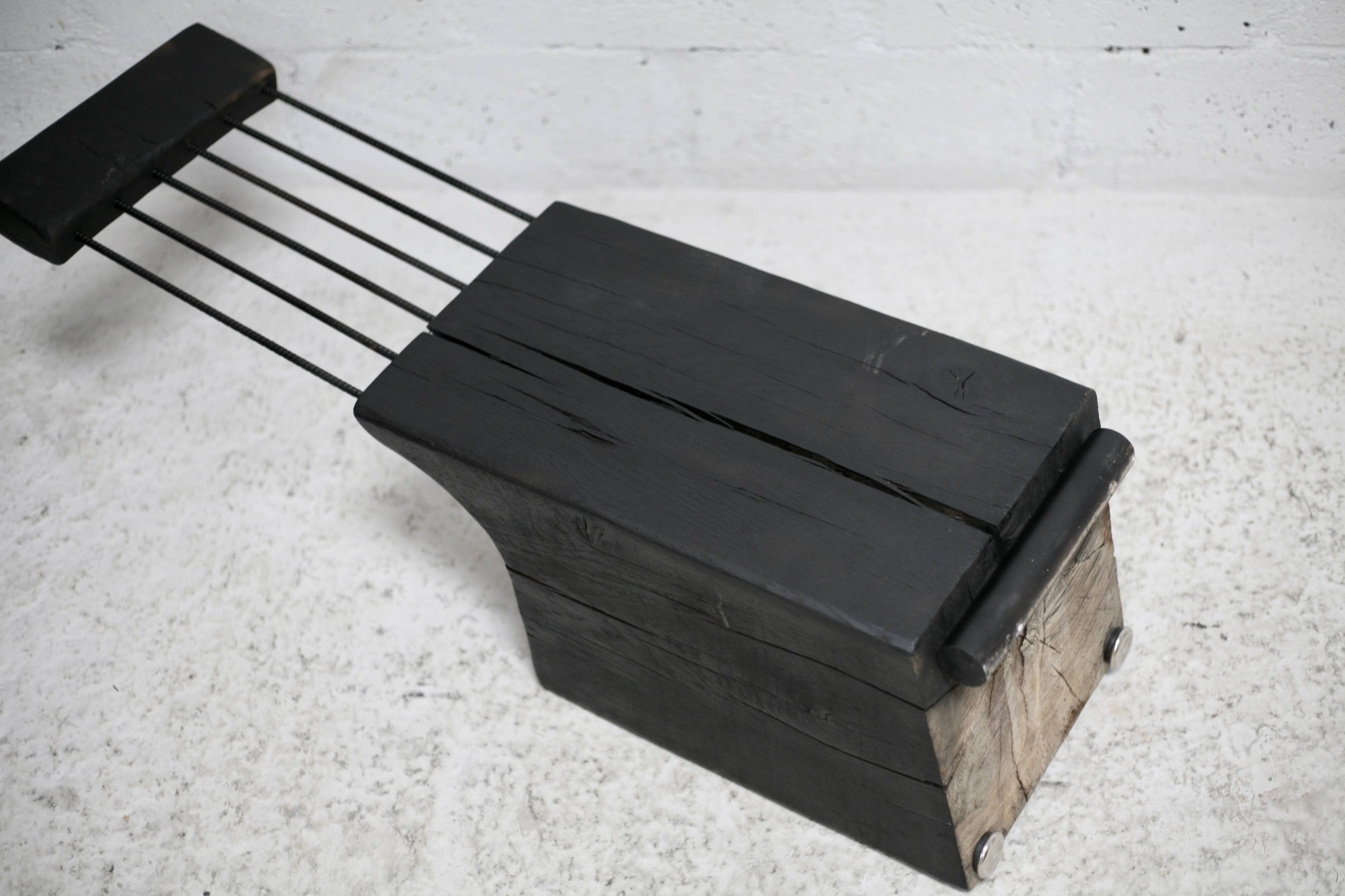 Brutalist chair, black-stained raw wood, steel. Work from the 1970s