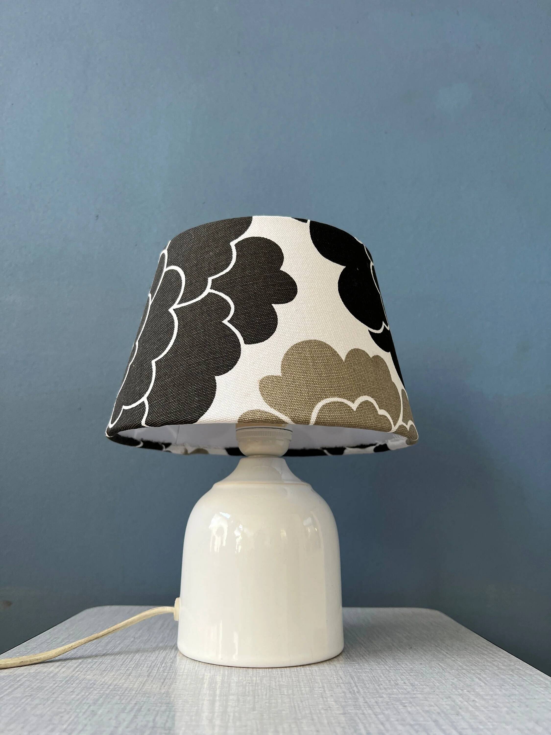 Small Space Age table lamp with a porcelain base and black and white flower shade.