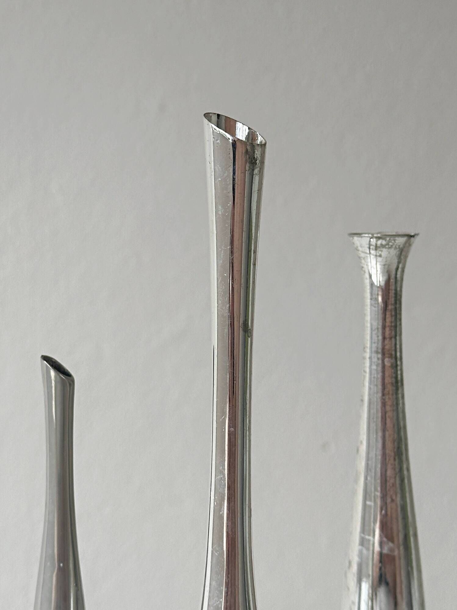 Set of three lightweight silver-coloured metal vases.