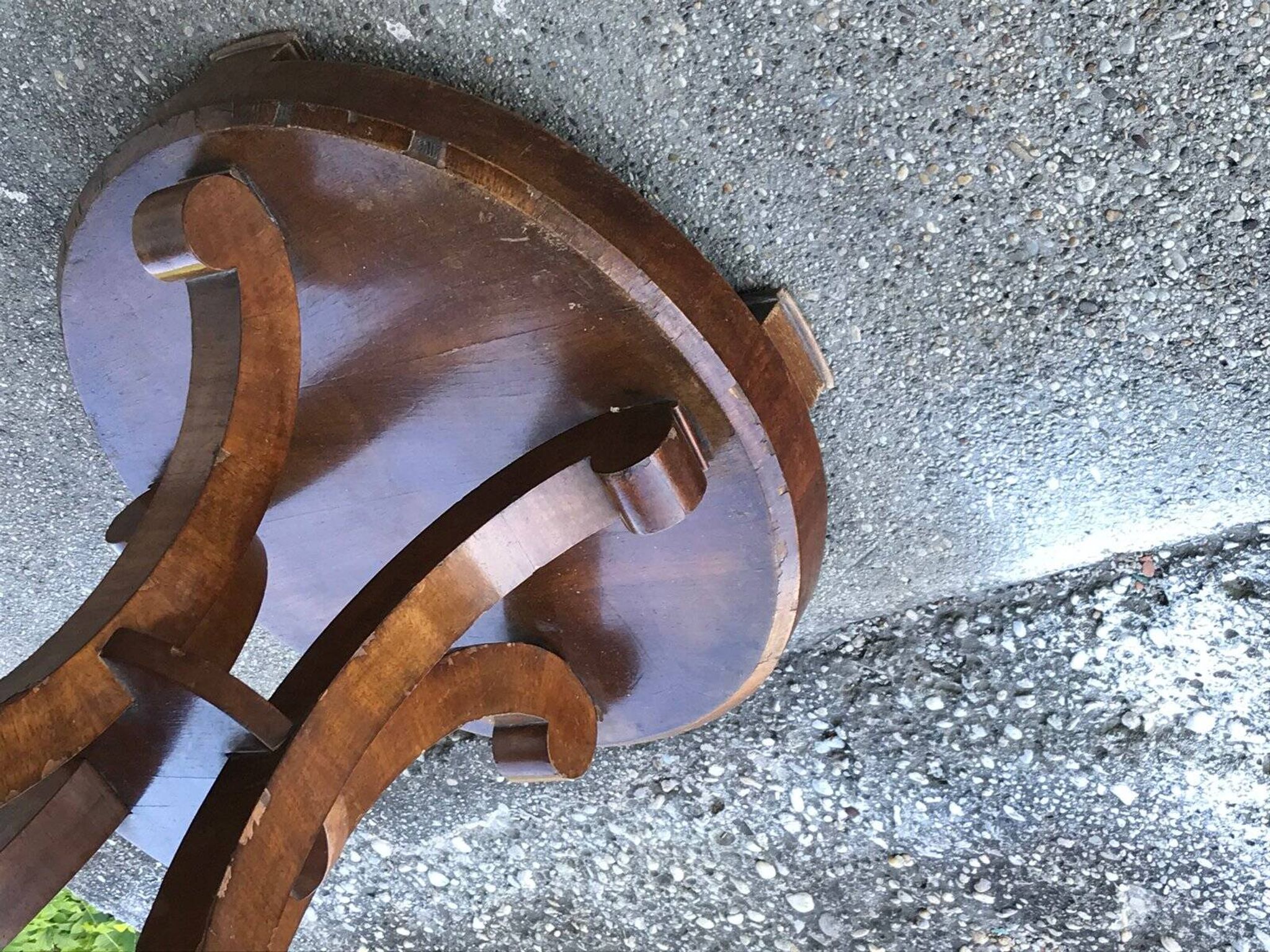 Art Deco side table in brown walnut, round top and scroll legs, France 1930s.