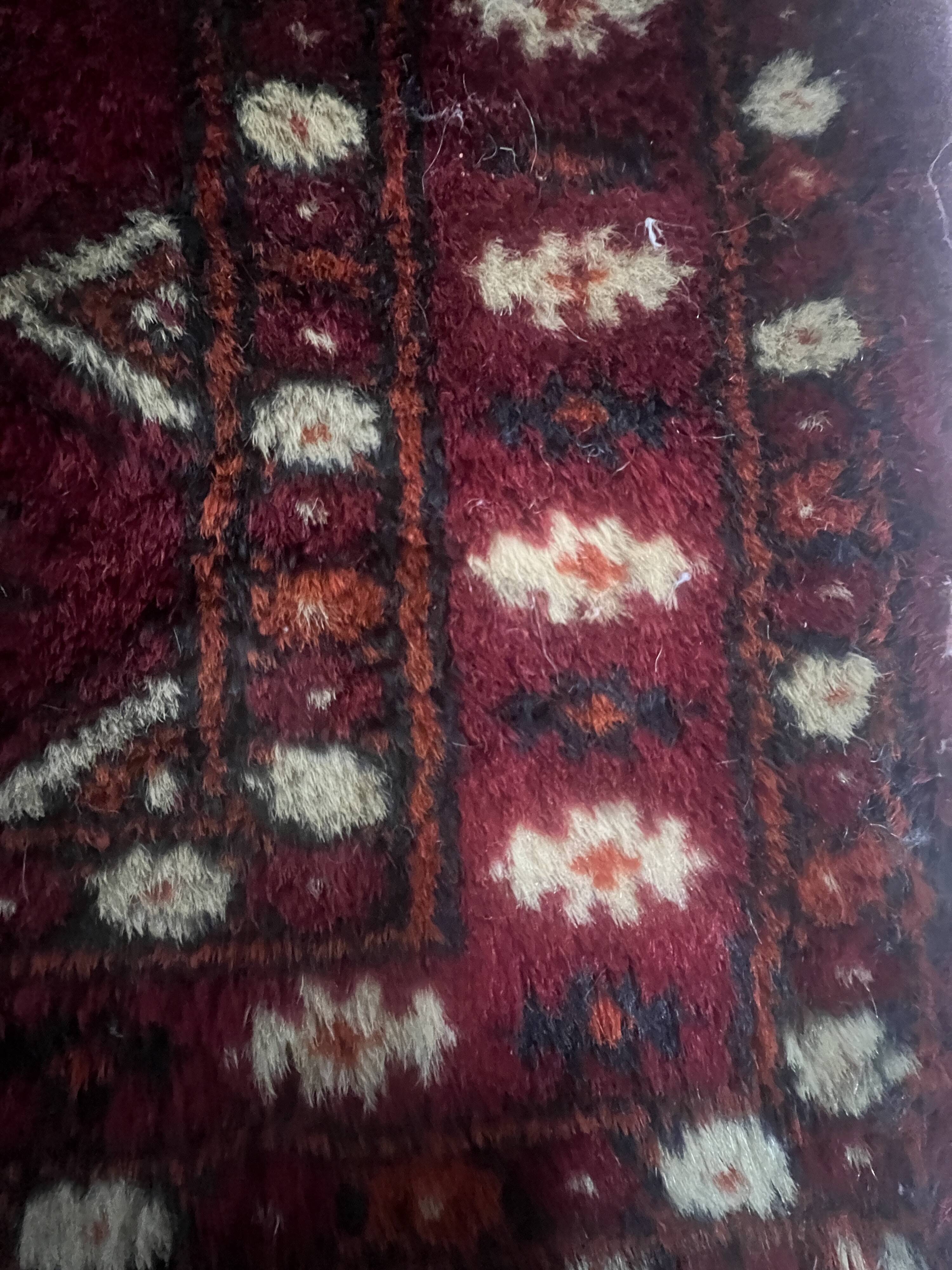 Antique wool rugs with designs on a red background, 20th century.