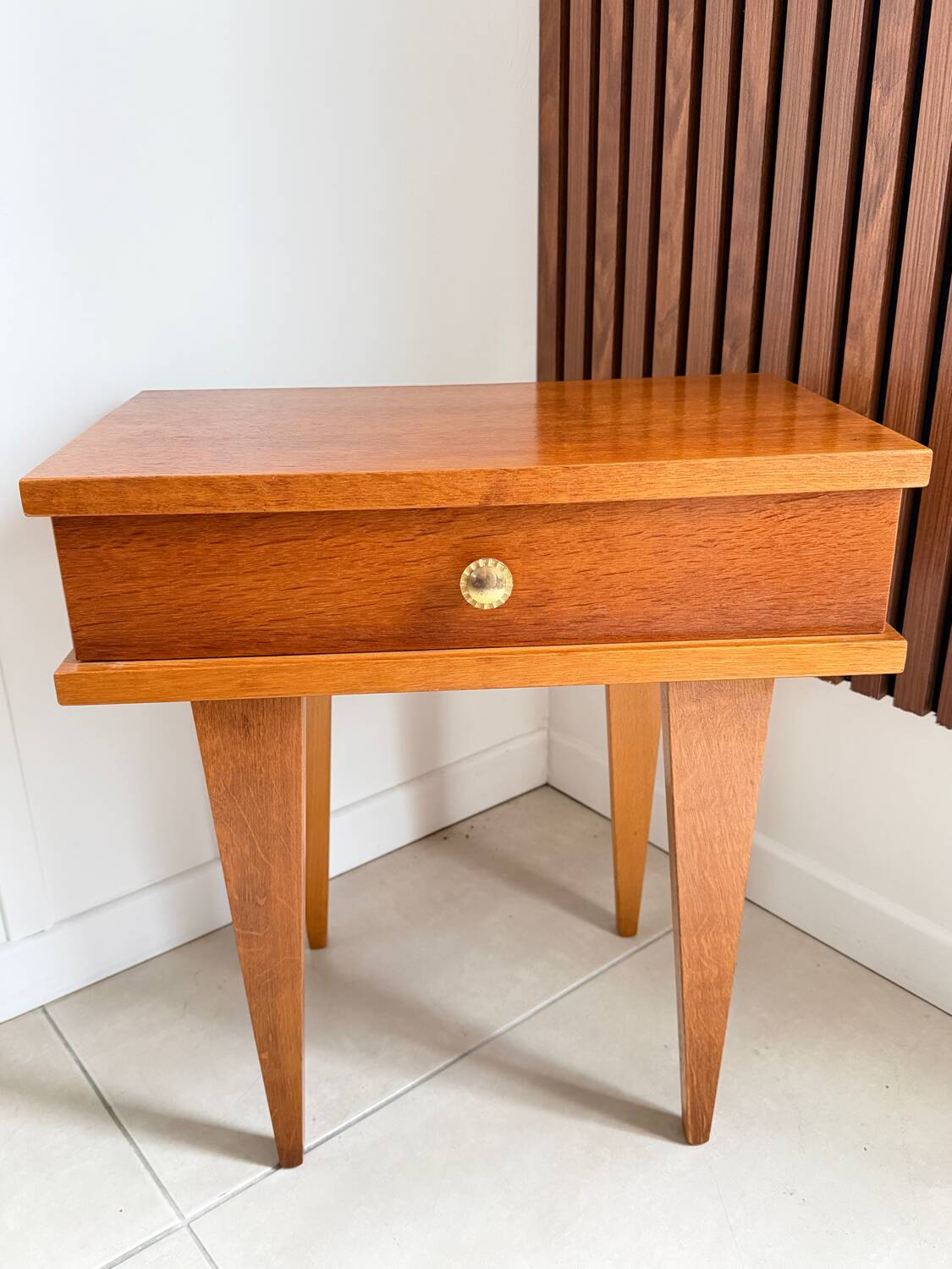 Vintage bedside table with tapered legs.