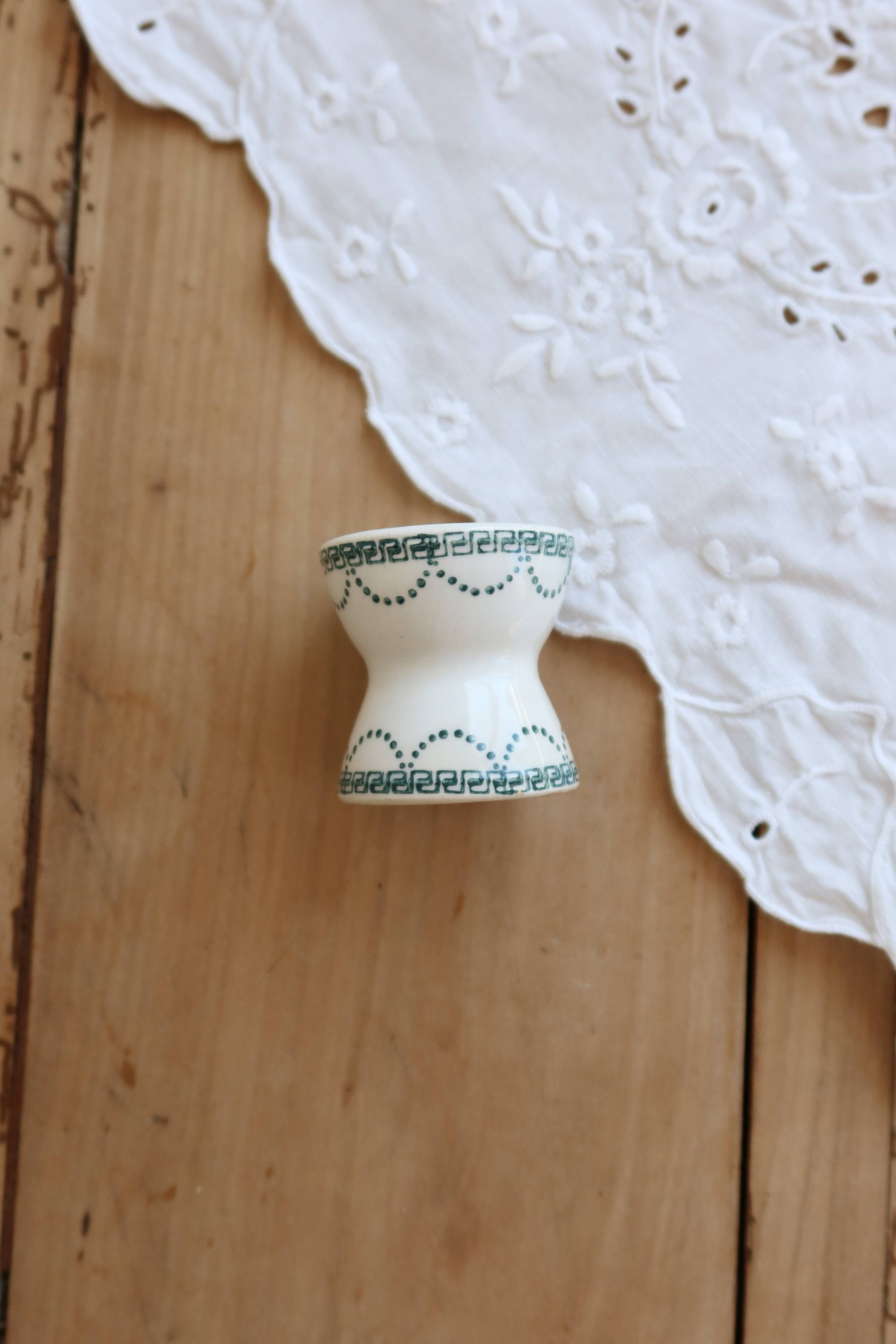 Old diabolo egg cup, ironstone with ivory and green pattern.