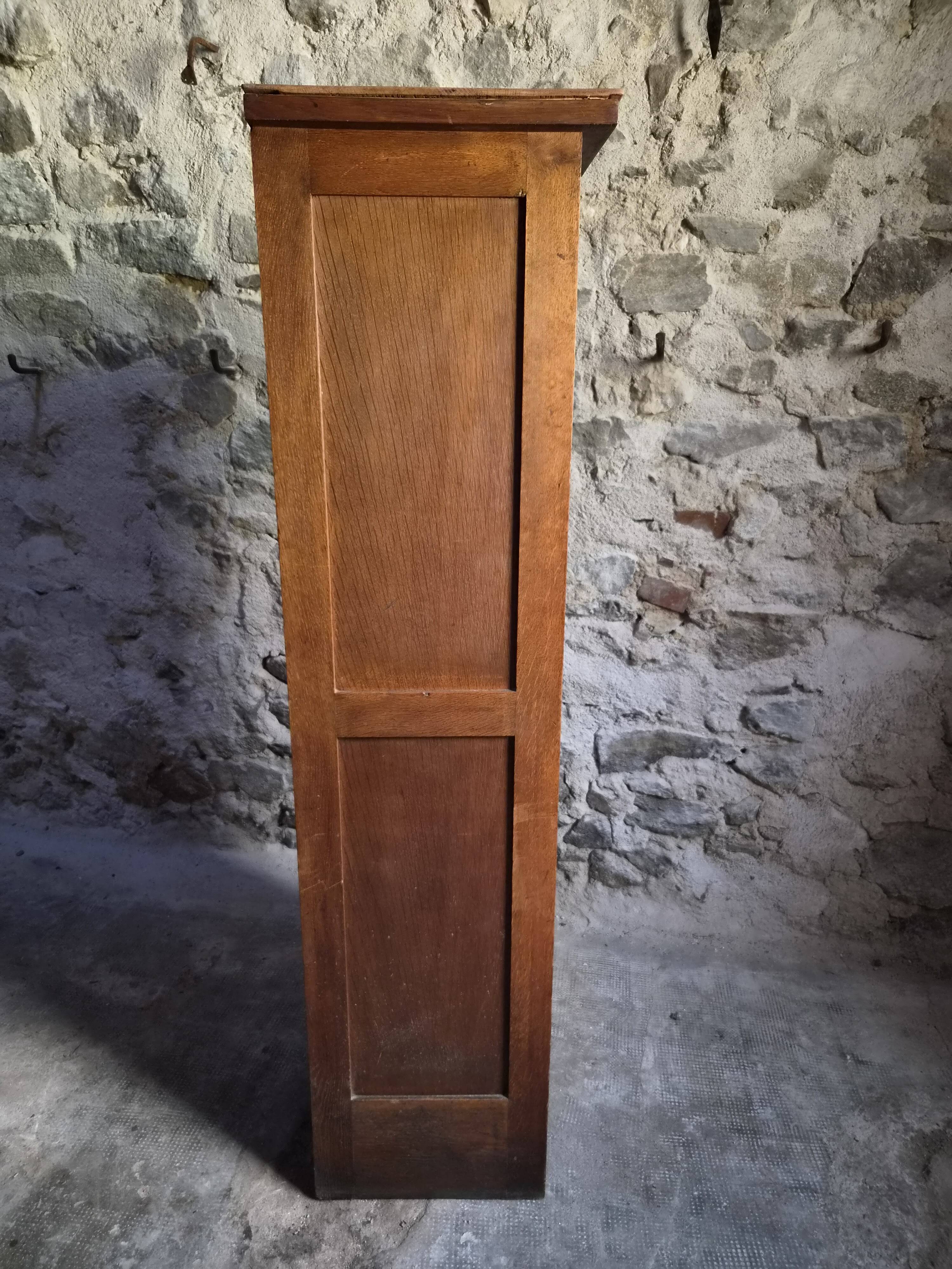 French antique wardrobe with curtain in oak, circa 1920–1930.