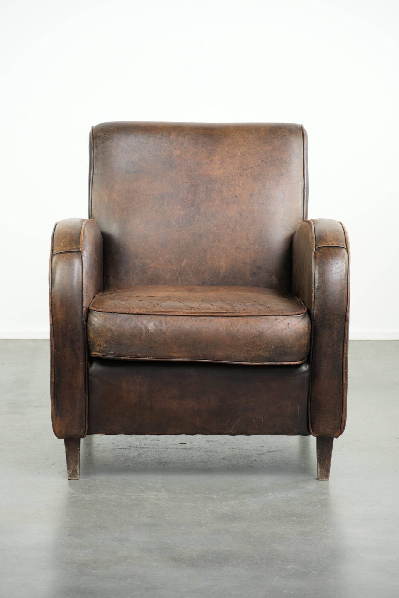 Comfortable sheepskin armchair with matching piping and a timeless look