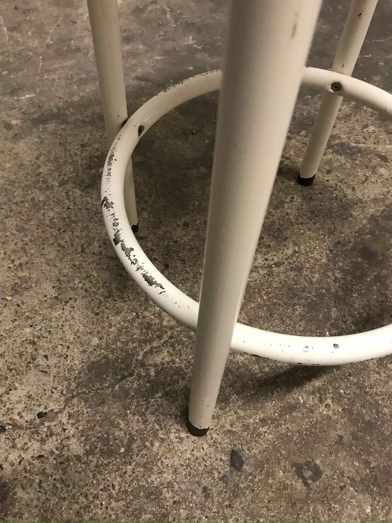 Vintage bar stool in white lace-up, round wooden seat rests circular feet