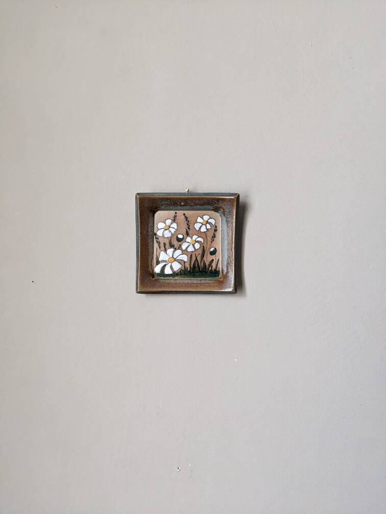 Handcrafted ceramic wall hanging with floral daisy decoration