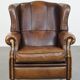 Vintage sheepskin wingback chair finished with black piping