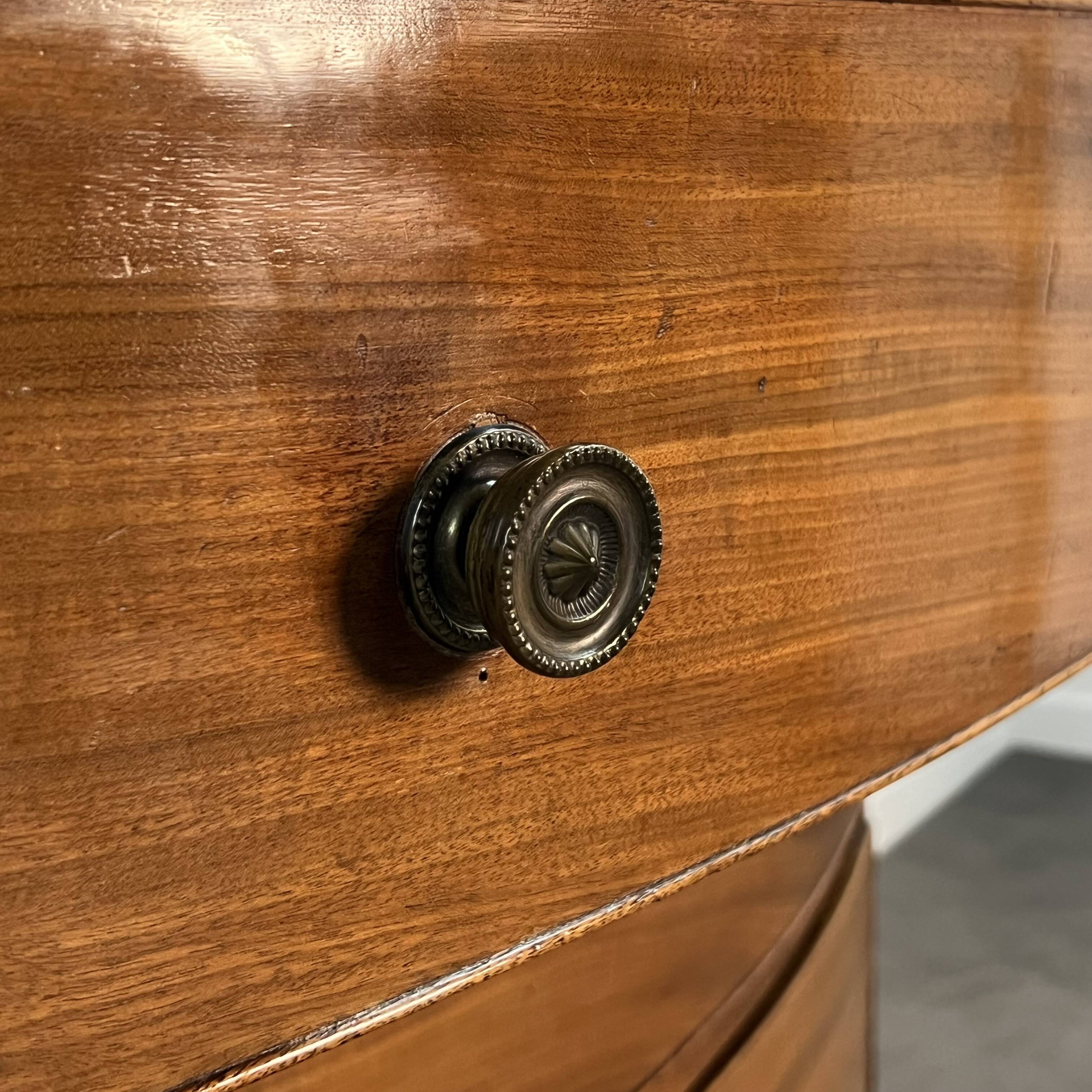 English commode from the George III Regency period, bombe shape in mahogany veneer.