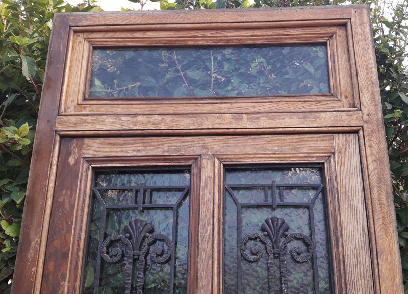 Oak entrance door and its frame and transom, wrought iron gates