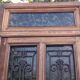 Oak entrance door and its frame and transom, wrought iron gates