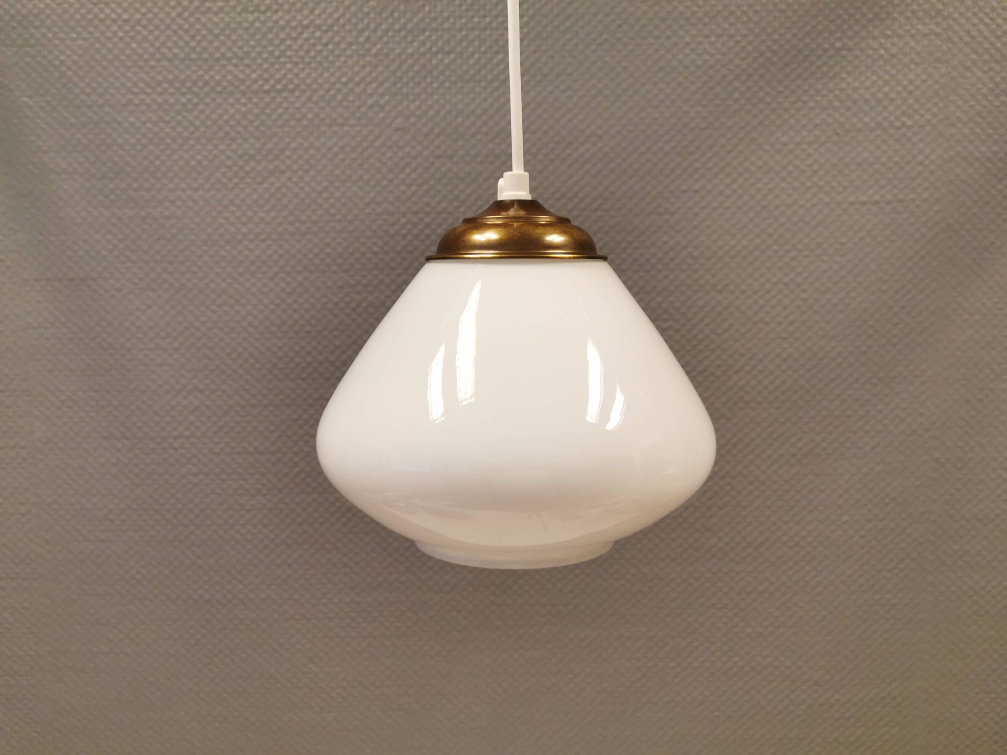 Beautiful ball-shaped hanging lamp in white opal glass with brass top.