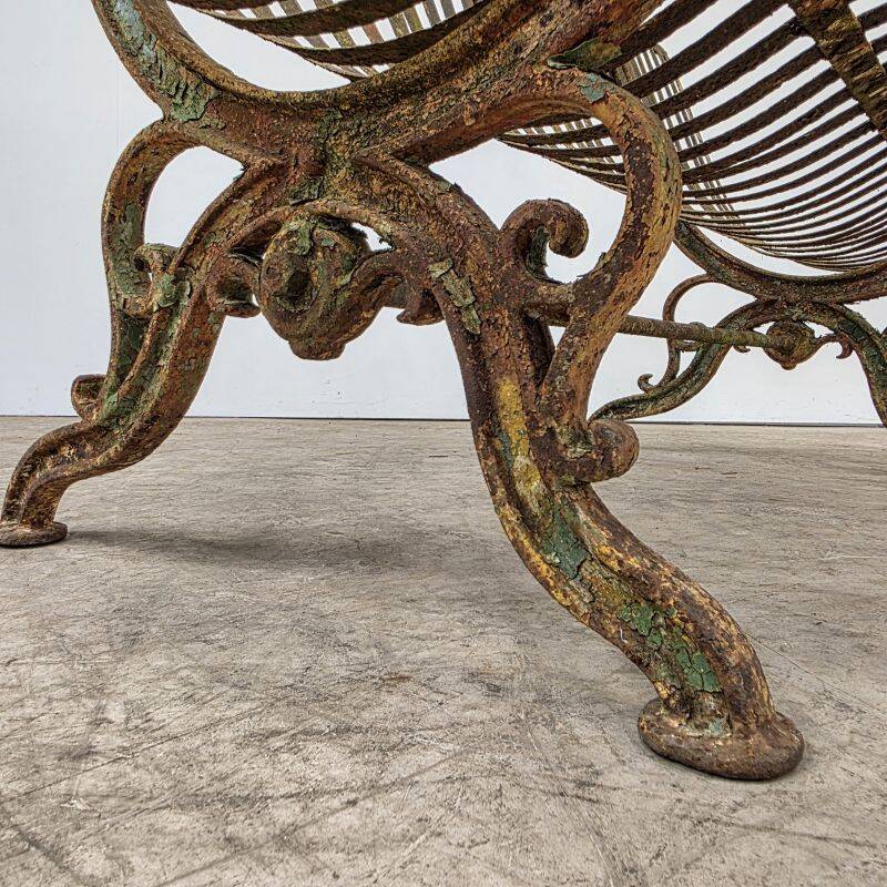 Cast iron garden bench from the late 19th century with slatted backrest.