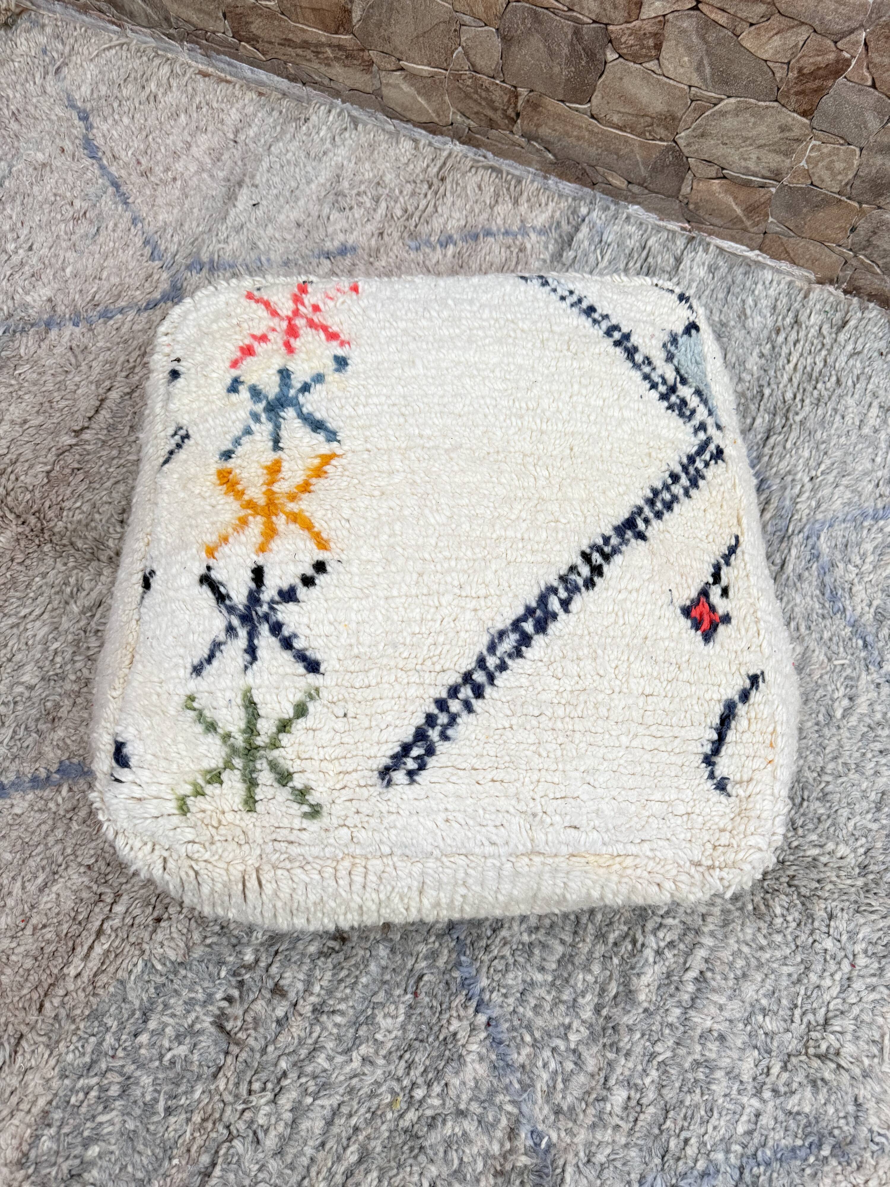 Berber floor pouf: Handwoven Moroccan wool cushion.