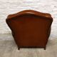 Antique club chair with gendarme hat back