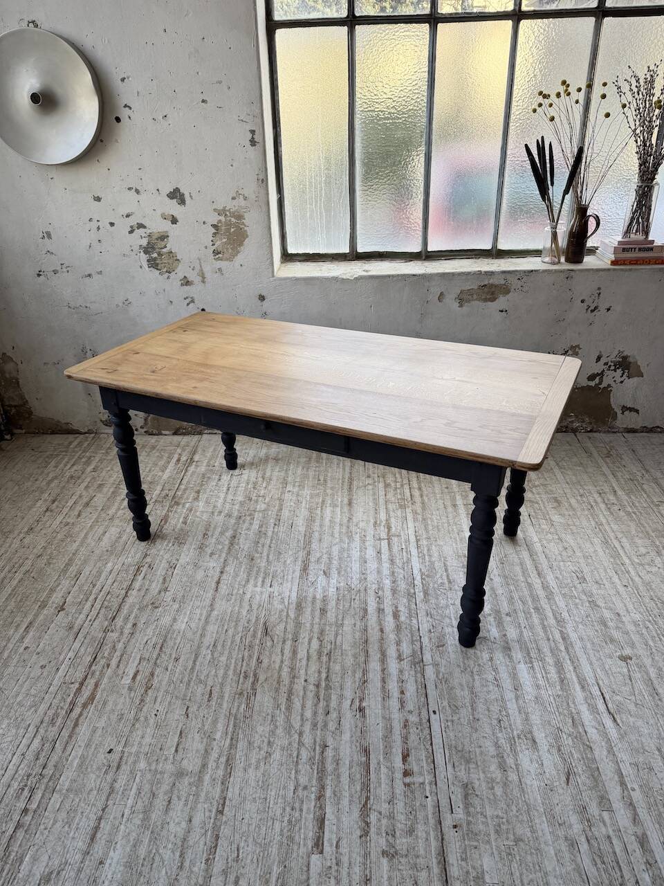 Oak farmhouse table with turned black legs.