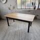 Oak farmhouse table with turned black legs.