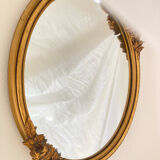 Oval mirror with a gilded frame and carved with bouquets of roses