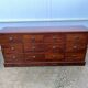 Old and authentic trade storage unit counter with 12 large drawers in cherry wood 1950