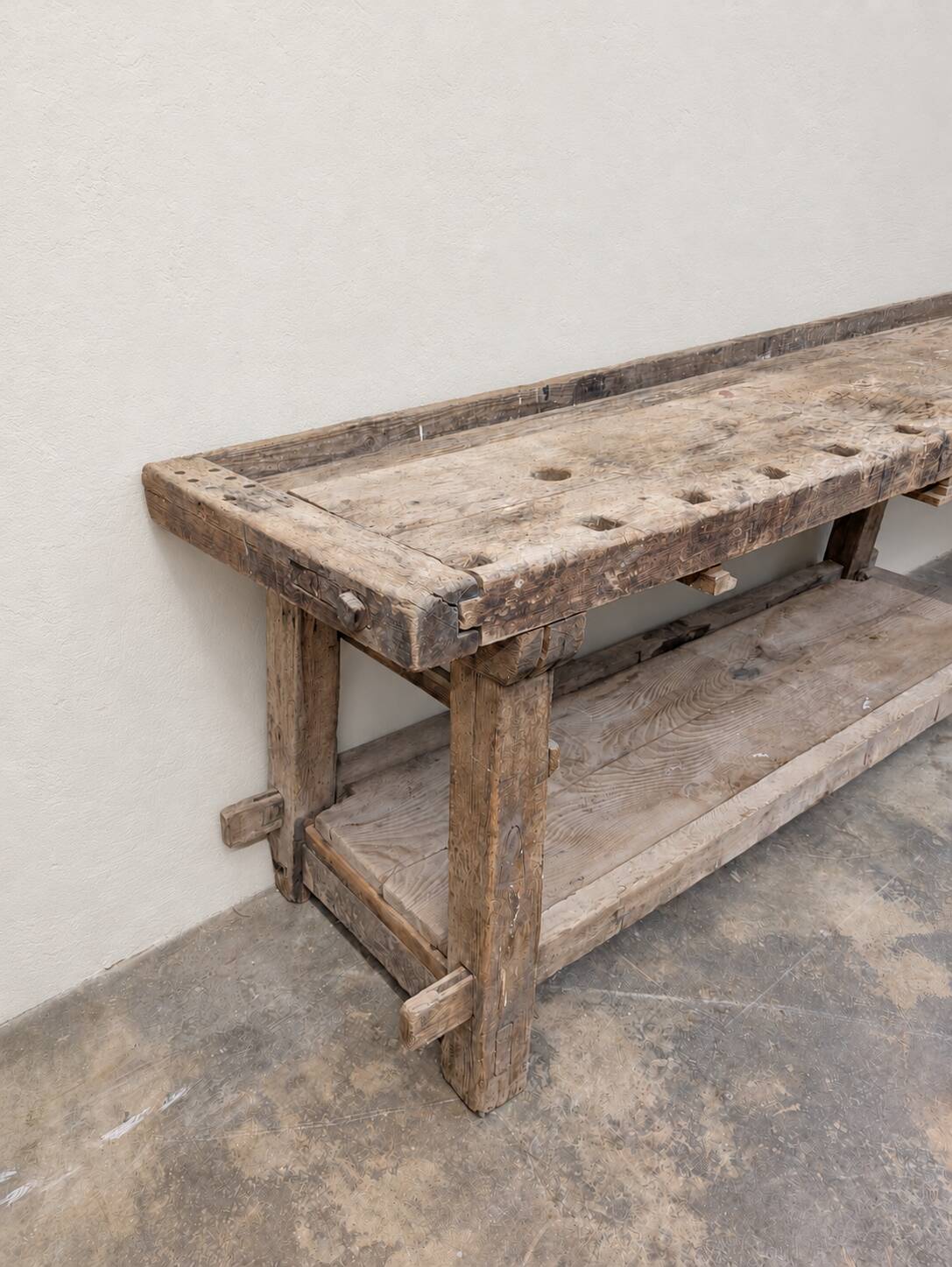Antique wooden workbench with a vice and drawer.