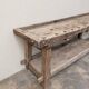 Antique wooden workbench with a vice and drawer.
