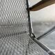 Pair of vintage silver aluminum wire folding chairs with wooden armrests — industrial minimalist