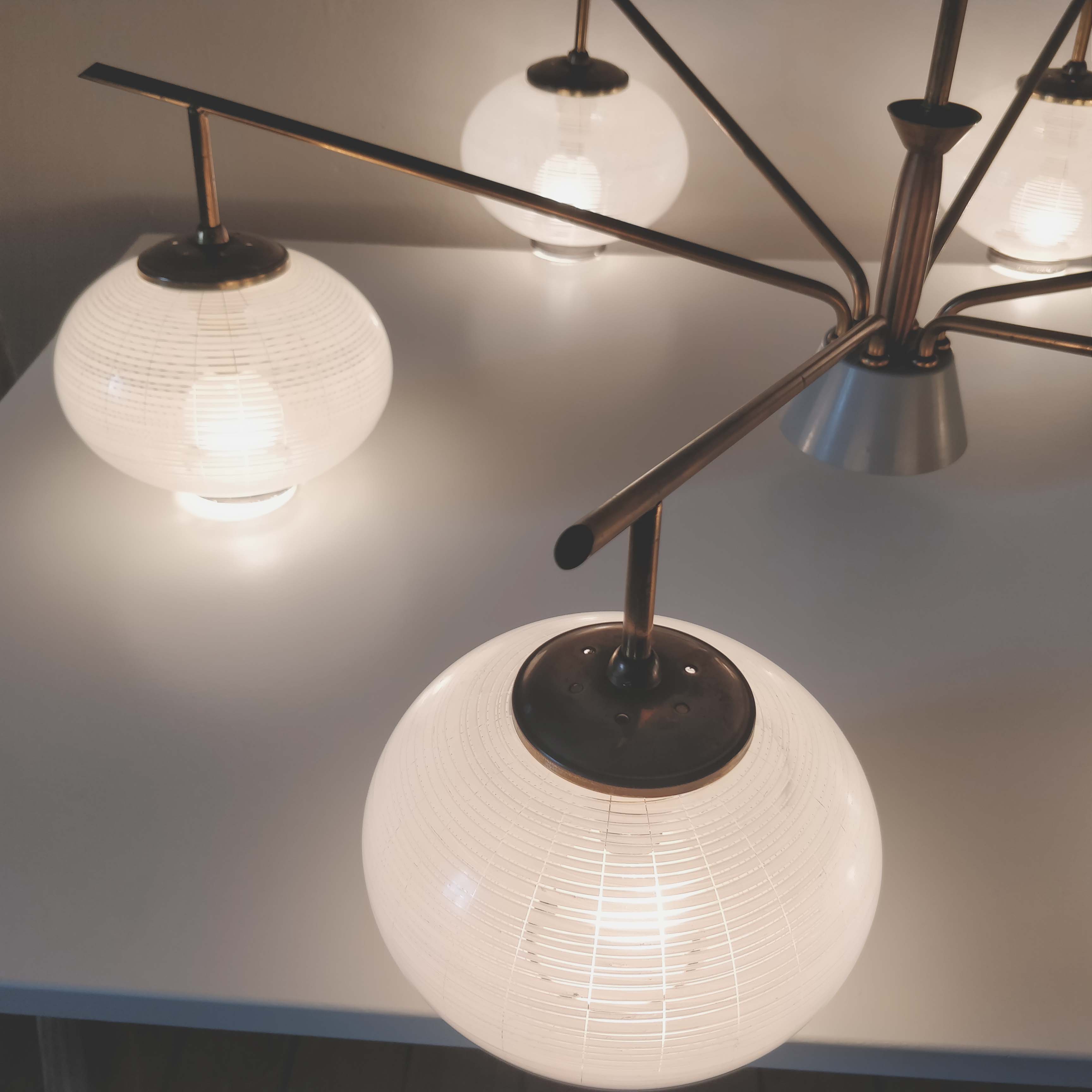 Brass chandelier and 6 white streaked glass globe lights