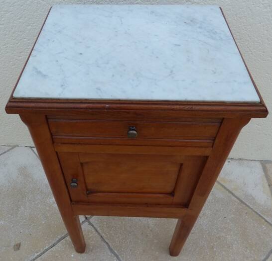 Antique bedside table with its marble top and white earthenware interior