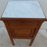 Antique bedside table with its marble top and white earthenware interior