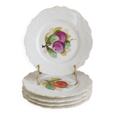 Antique plates from the late 19th century with scalloped edges and fruit decoration.