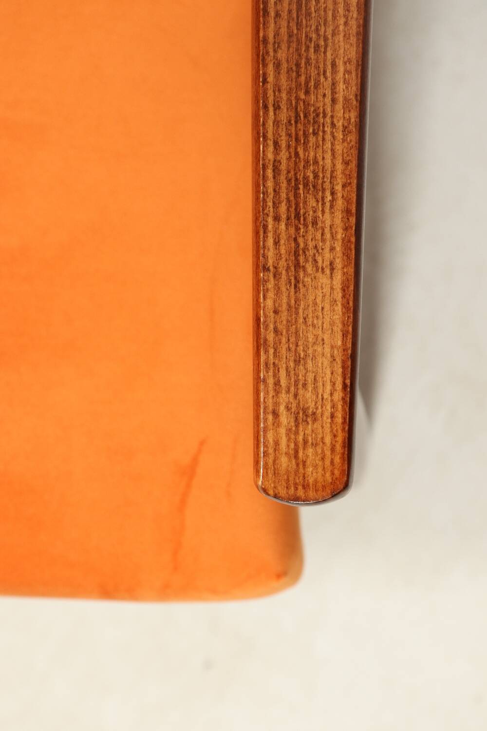 Modern armchair in orange papaya velvet with dark brown wood, 1970s Scandinavian style.