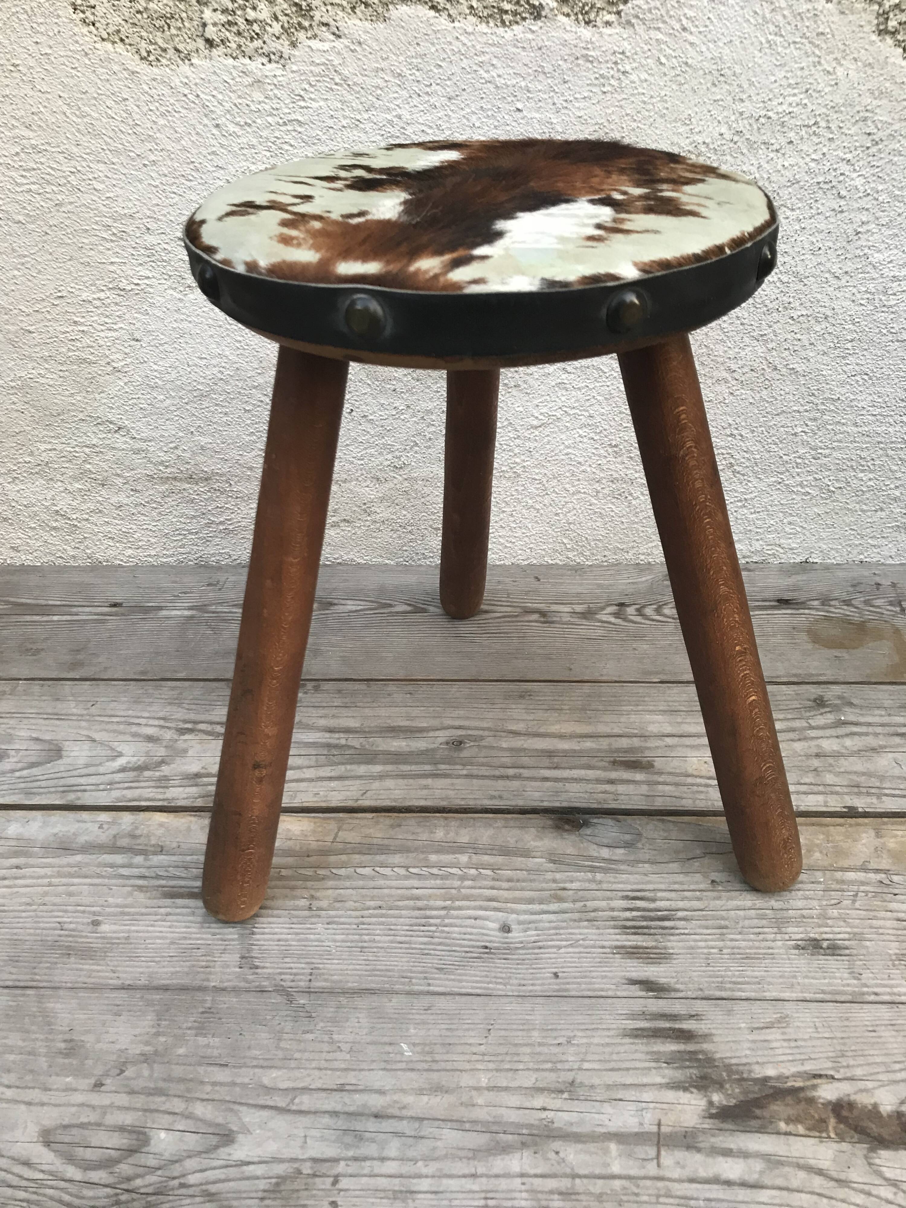 Old wooden tripod stool with seat leather vintage