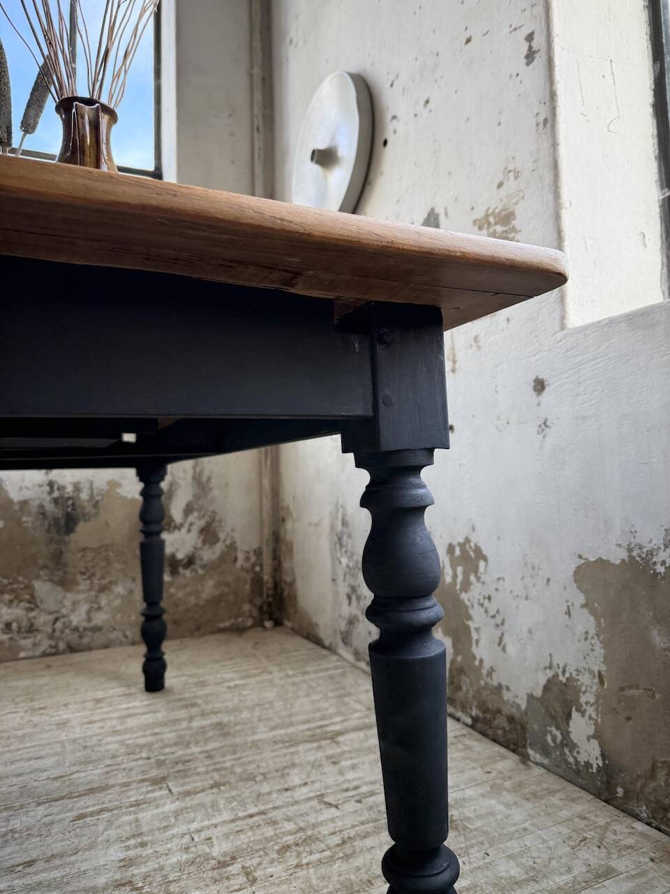 Oak farmhouse table with turned black legs.
