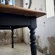 Oak farmhouse table with turned black legs.