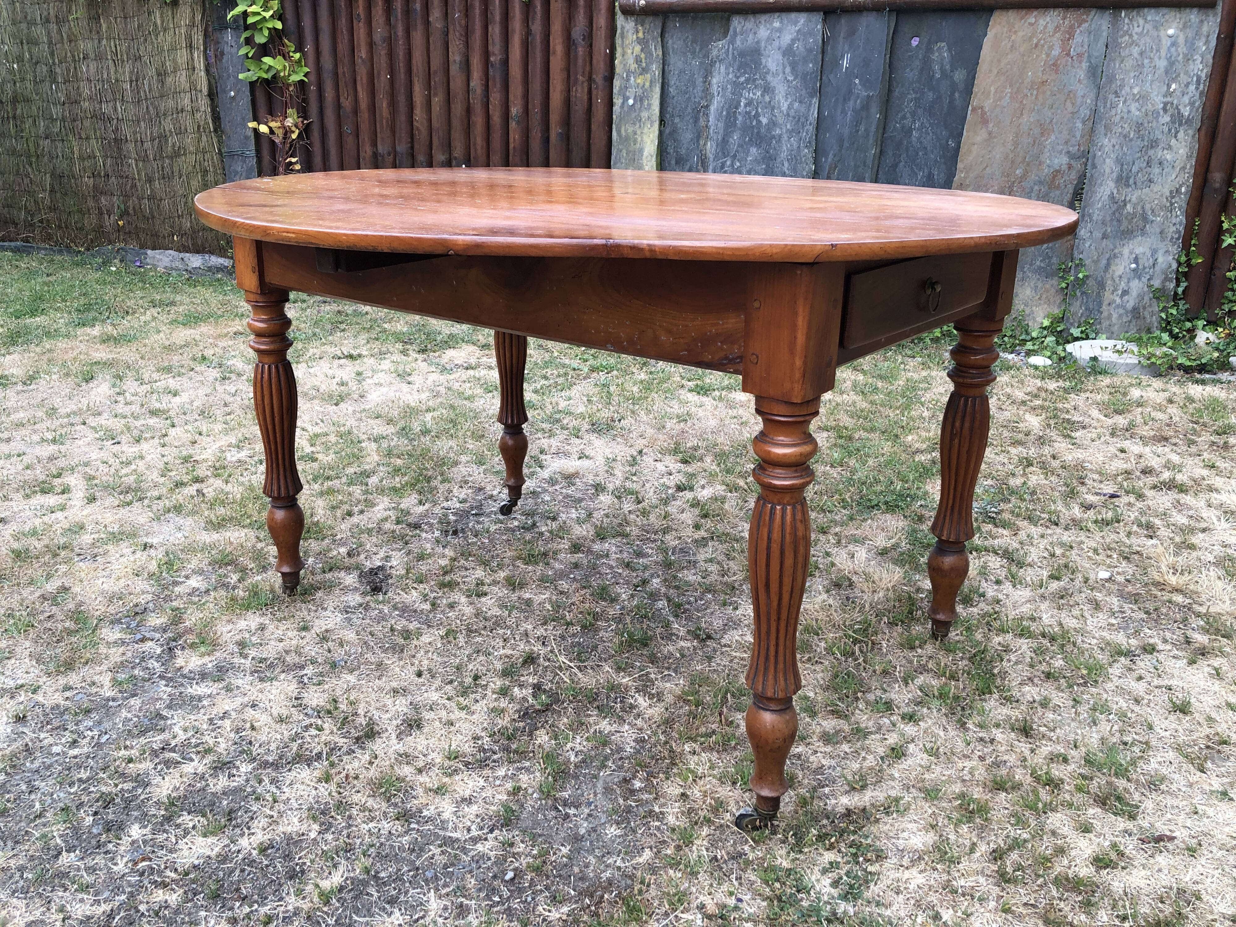 Louis Philippe oval drop-leaf table in solid cherry wood with 2 drawers.