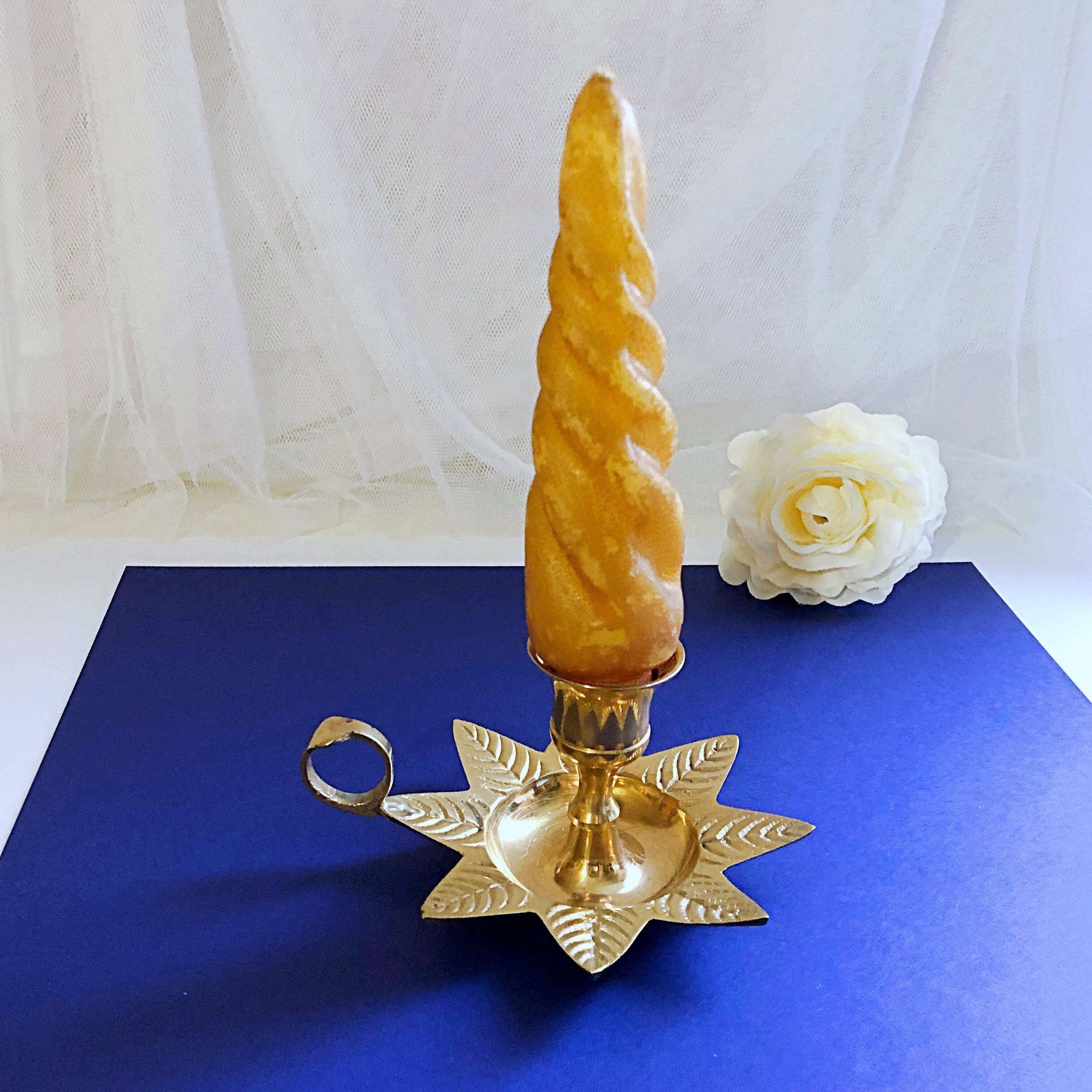Golden brass hand candle holder decorated with leaves