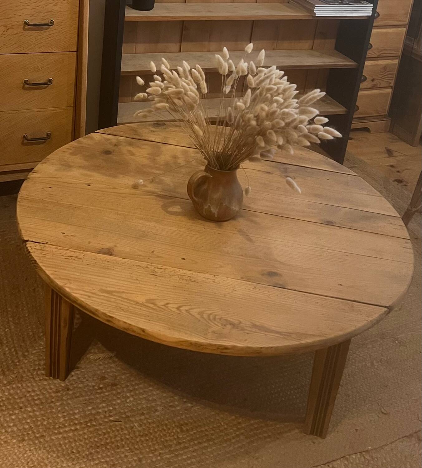 Large round antique coffee table made of raw solid wood.