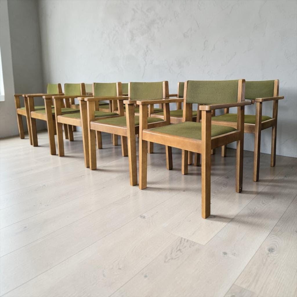 Vintage wooden chair with olive green seat and armrests.