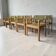 Vintage wooden chair with olive green seat and armrests.