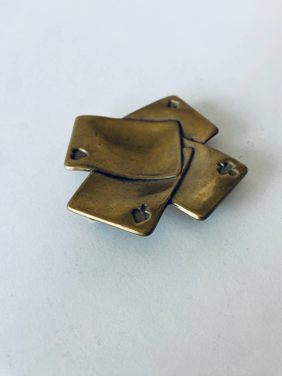 Empty pocket square of aces in brass