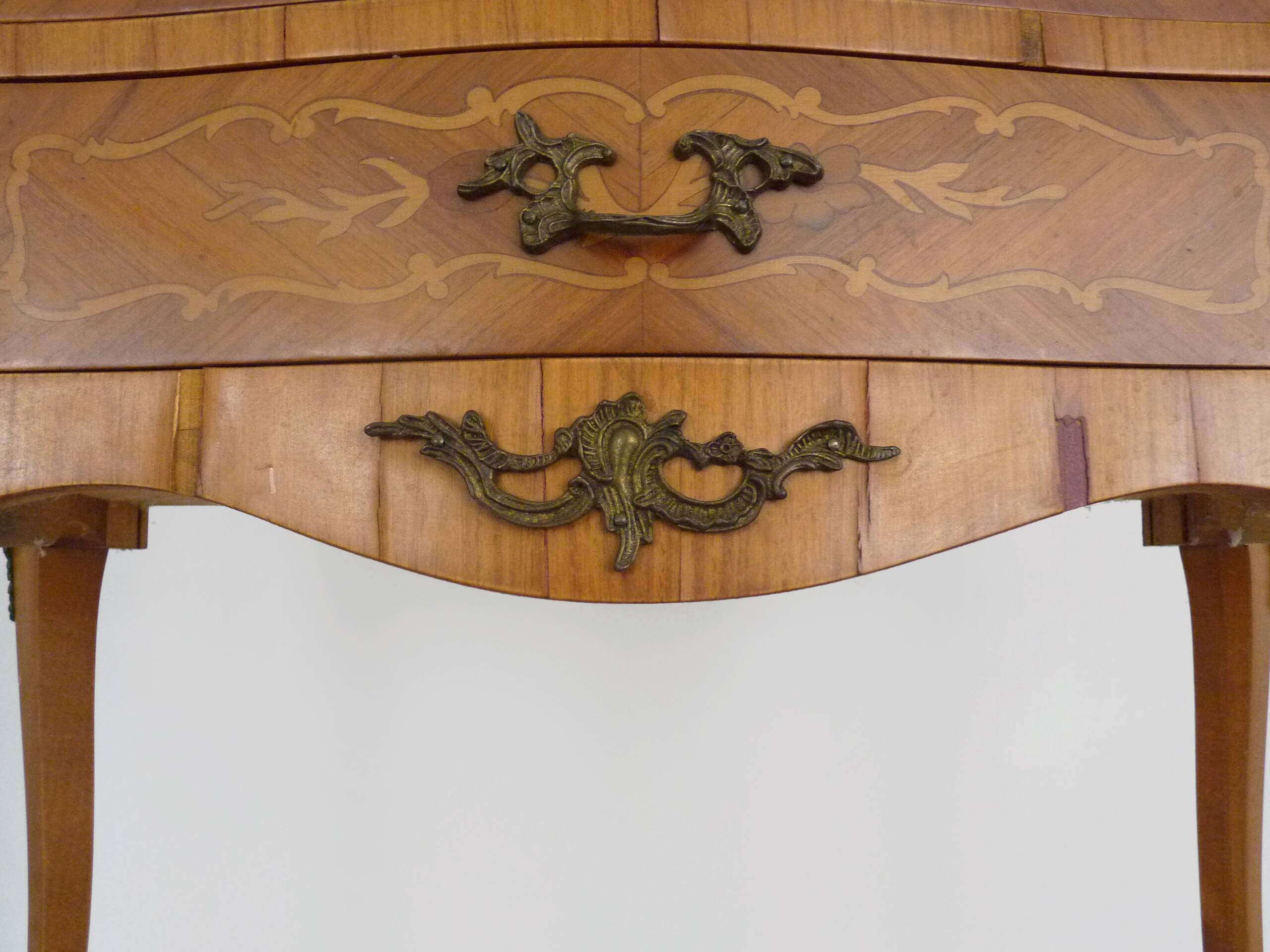 Baroque style wooden chest of drawers with bronze frieze.