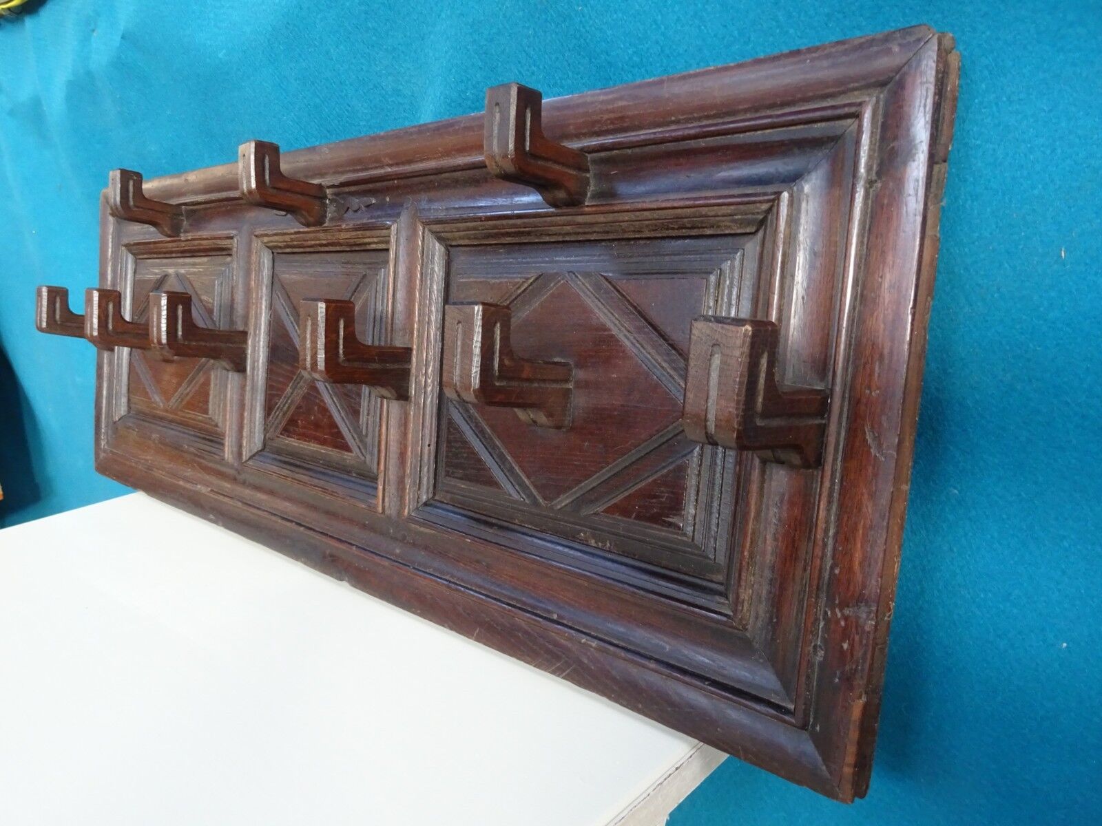Wall-mounted coat rack in solid oak with 9 hooks.