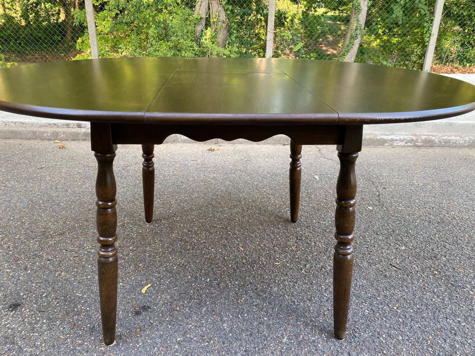 Extendable round table in solid wood with a dark oak satin finish.