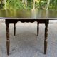 Extendable round table in solid wood with a dark oak satin finish.