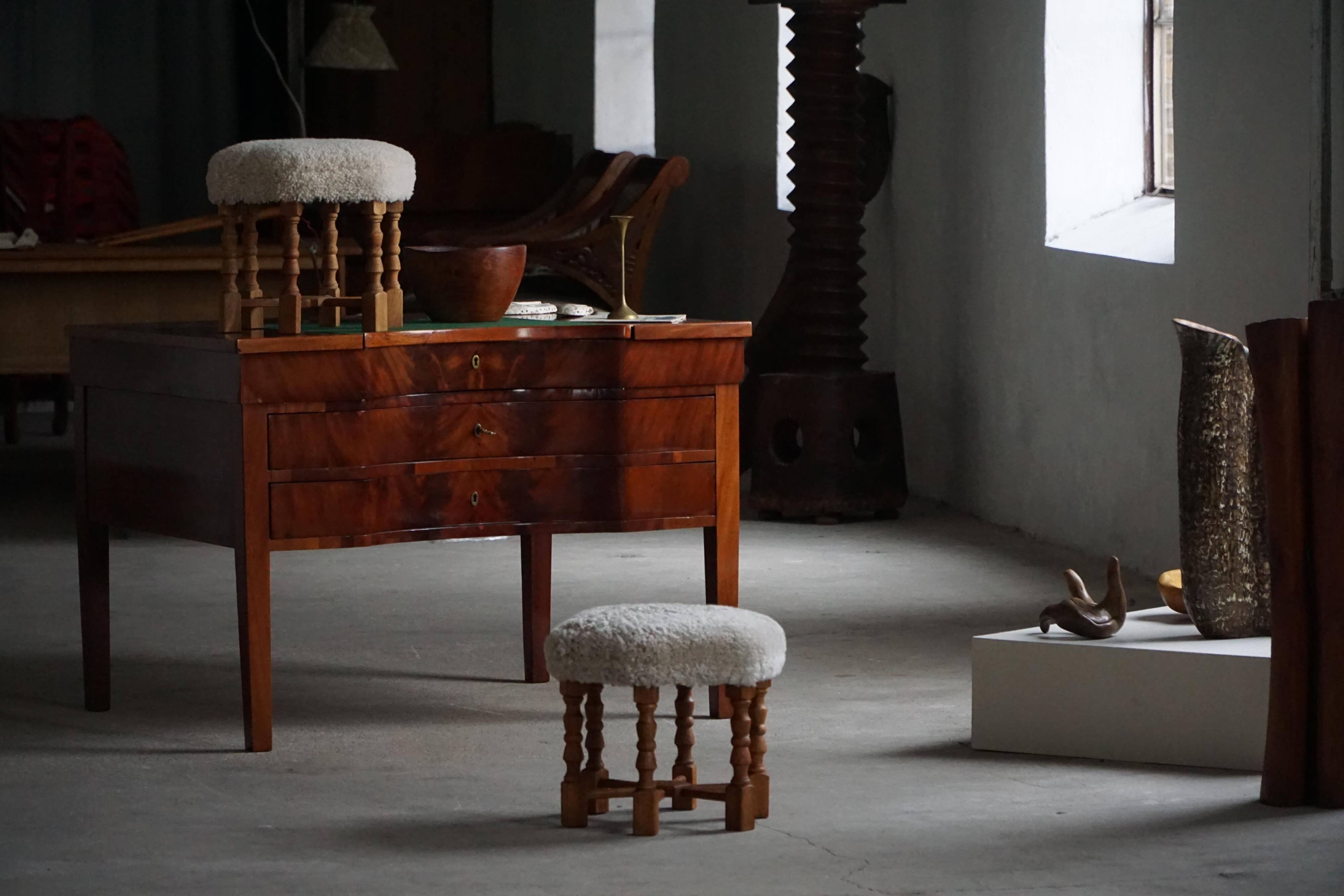 Pair of mid-century Danish oak stools with shearling lambswool upholstery, 1950s.