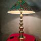 This elegant table lamp features a sculptural base in shiny gold brass.